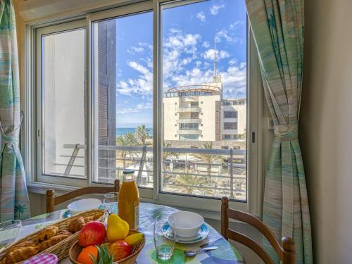 une table avec une assiette de fruits et une vue sur une ville dans l'établissement Apartment Le Sunset-Cap Sud-23 by Interhome, au Cap d'Agde