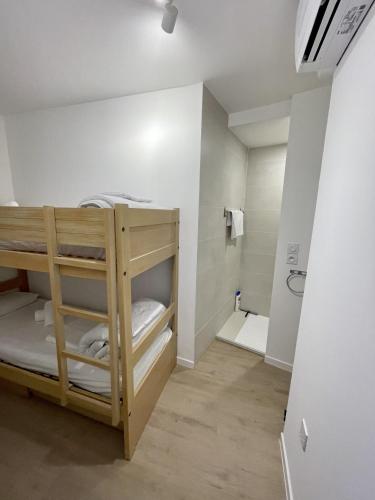 a room with a bunk bed and a bathroom at BADINE BEACH piscine balnéo clim in Hyères