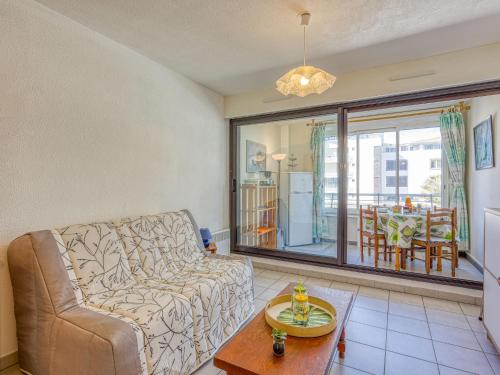 un salon avec un canapé et une table dans l'établissement Apartment Le Sunset-Cap Sud-23 by Interhome, au Cap d'Agde
