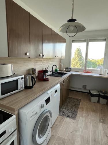 une cuisine avec un lave-linge et un micro-ondes dans l'établissement Appartement T5 standing 104m2, à Orléans
