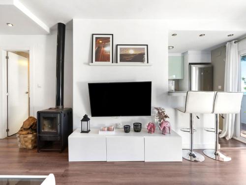 uma sala de estar branca com uma televisão e um fogão em Apartment Mediterráneo by Interhome em Puerto Marino