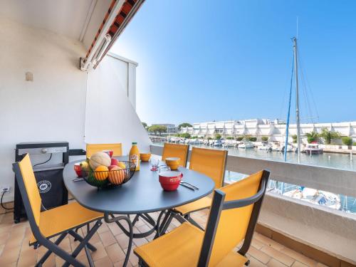 une table avec un bol de fruits sur un balcon dans l'établissement Apartment Le Nirvana-3 by Interhome, au Grau-du-Roi