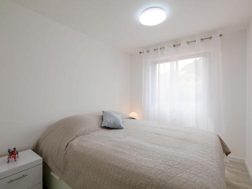 une chambre blanche avec un lit et une fenêtre dans l'établissement Apartment La Palmeraie II-13 by Interhome, à Sainte-Maxime