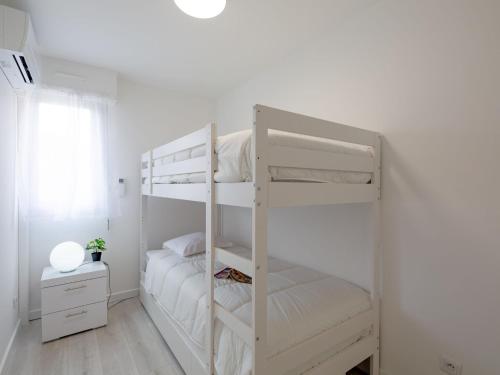 Ce lit superposé blanc se trouve dans une chambre blanche. dans l'établissement Apartment La Palmeraie II-13 by Interhome, à Sainte-Maxime
