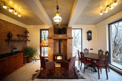 a living room with a table and a fireplace at Villa Vejini in Mamkoda