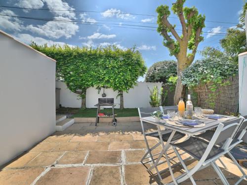 Un patio con una mesa y sillas en un patio. en Holiday Home Le Moulin de la Filasse by Interhome, en Le Trait dʼUnion