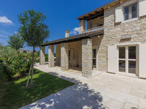 an external view of a stone house with a patio at Holiday Home Villa Anita by Interhome in Momjan