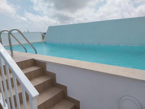 eine Treppe, die zu einem Pool mit blauem Wasser führt in der Unterkunft St gaetans studio apartment 6A in Tas-Samra