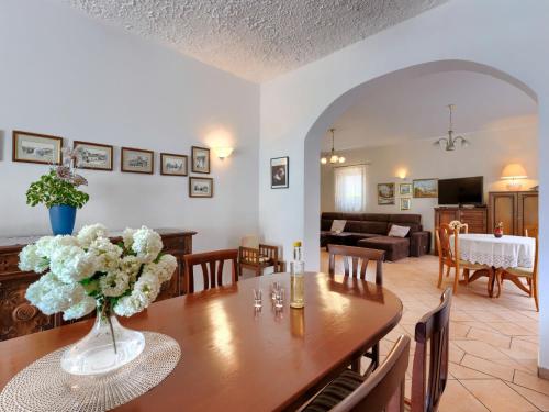 Un comedor y sala de estar con mesa y flores. en Holiday Home Villa Moj Mir by Interhome, en Nova Vas
