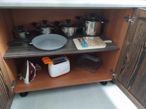 a cabinet with pots and pans and a plate on a shelf at St gaetans studio apartment 6A in Tas-Samra