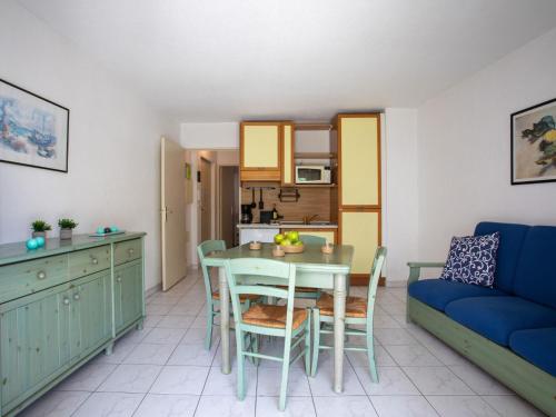 un salon avec une table et un canapé bleu dans l'établissement Apartment Parc Vaugrenier by Interhome, à Villeneuve-Loubet
