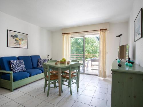 un salon avec un canapé bleu et une table dans l'établissement Apartment Parc Vaugrenier by Interhome, à Villeneuve-Loubet