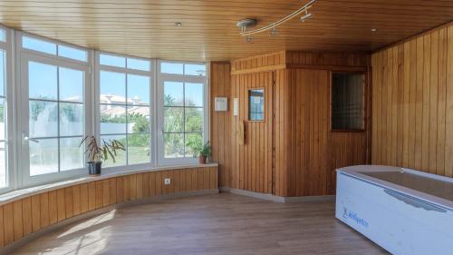 ein großes Bad mit einer Badewanne und Fenstern in der Unterkunft Praia Grande Guest House in Colares
