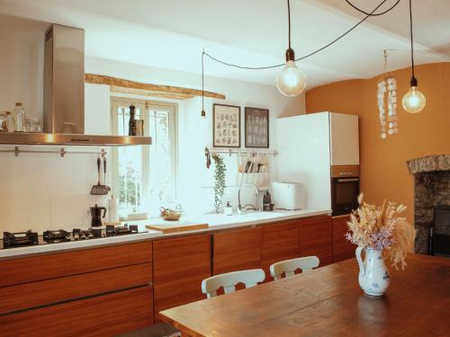 a kitchen with wooden cabinets and a wooden table at Holiday Home Niosa by Interhome in Dego