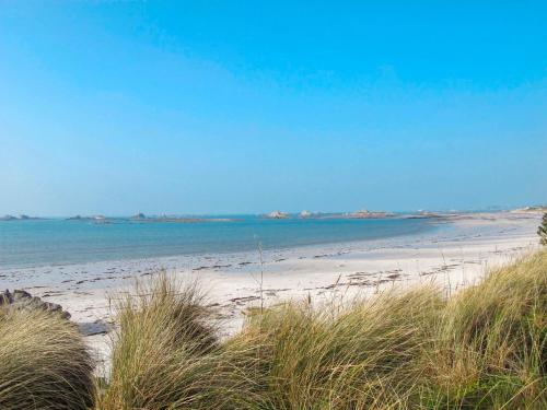 a beach with sand and the ocean in the background at Holiday Home Maison du Venec by Interhome in Santec