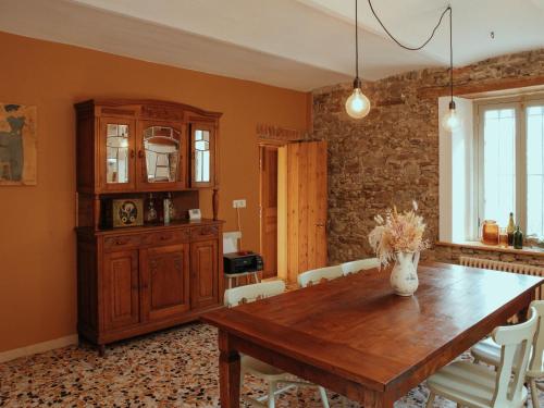 a dining room with a wooden table and white chairs at Holiday Home Niosa by Interhome in Dego