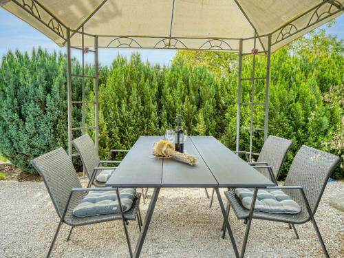 a table and chairs under an umbrella on a patio at Apartment Ani by Interhome in Kastav