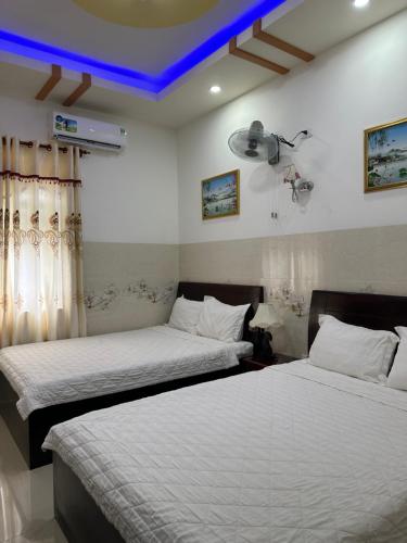 - 2 lits dans une chambre dotée d'un plafond bleu dans l'établissement Ngọc Nam Hotel, à La Gi