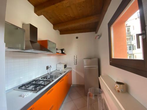una cocina con armarios naranjas, fregadero y ventana en Apartment Orcagna apartment by Interhome, en Florencia