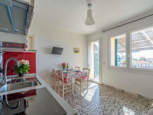 a kitchen with a sink and a table with chairs at Apartment Ruscus by Interhome in Terzorio