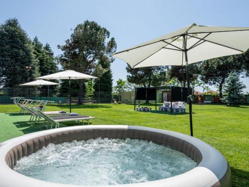 a hot tub with an umbrella in a yard at Holiday Home Casa Giacomelli by Interhome in Mathi