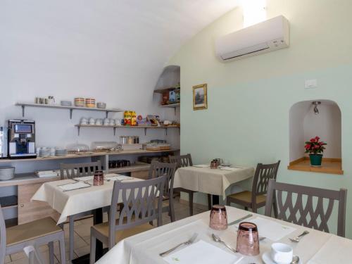 a restaurant with tables and chairs and a kitchen at Apartment Ruscus by Interhome in Terzorio