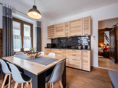 - une cuisine avec des placards en bois, une table et des chaises en bois dans l'établissement Apartment Il Fior di Neve by Interhome, à Prali