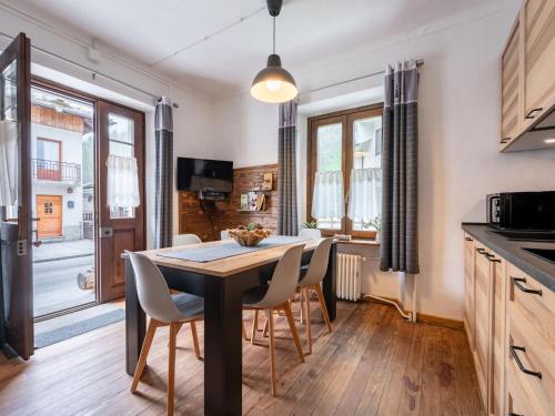 - une cuisine et une salle à manger avec une table et des chaises dans l'établissement Apartment Il Fior di Neve by Interhome, à Prali