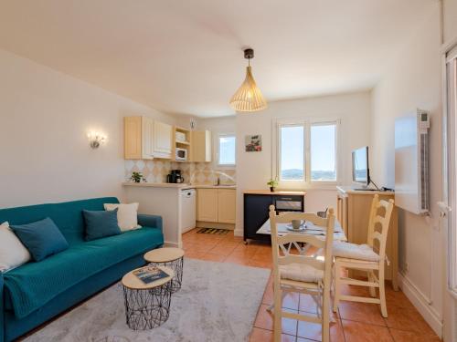 un salon avec un canapé bleu et une table dans l'établissement Apartment Résidence Bellevue-1 by Interhome, à Roquebrune-sur Argens