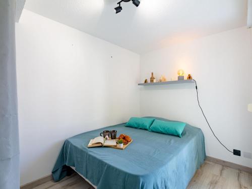 - une chambre avec un lit doté d'une couverture bleue et d'une étagère dans l'établissement Apartment Le Riviera-3 by Interhome, à Saint-Aygulf