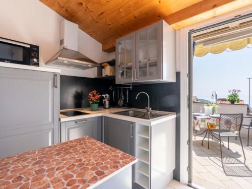 - une cuisine avec des placards blancs, un évier et une table dans l'établissement Apartment Fico by Interhome, à Terzorio