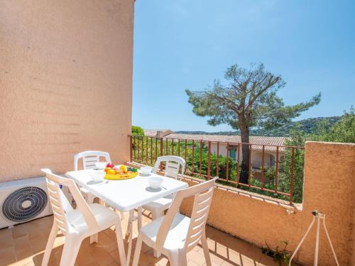 une table et des chaises blanches sur un balcon avec un arbre dans l'établissement Apartment Les Cigalines by Interhome, à Cavalaire-sur-Mer