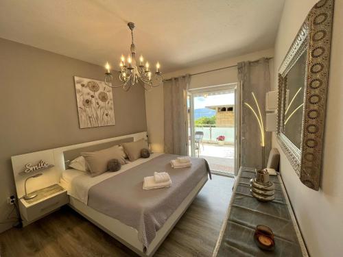 a bedroom with a bed with a chandelier and a window at Apartment Merlin in Bol