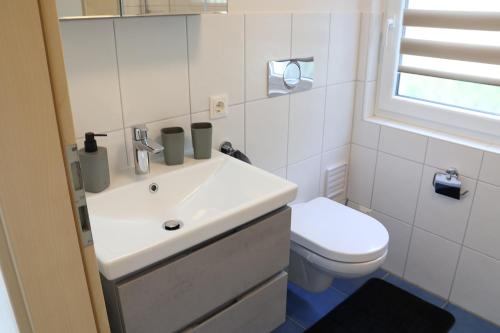a bathroom with a white sink and a toilet at Ferienwohnung Familie Strehl in Frickingen