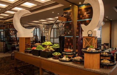 a buffet line with plants and a large letter q at Sheraton Mall of the Emirates Hotel, Dubai in Dubai