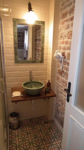 a bathroom with a green sink and a mirror at Gizemli Konak in Ayvalık