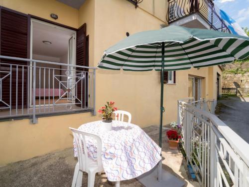 - une table avec un parasol vert et blanc sur le balcon dans l'établissement Apartment Miky by Interhome, à Massa Lubrense