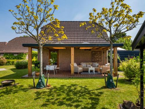 patio trasero con terraza de madera y sala de estar en Holiday Home Haus Anni by Interhome en Wolphaartsdijk