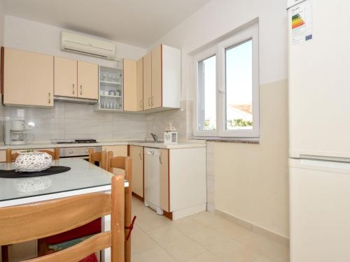 a kitchen with white cabinets and a white refrigerator at Holiday Home Irma by Interhome in Sukošan