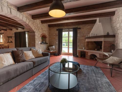 sala de estar con sofá y chimenea en Holiday Home Villa Farfalla by Interhome, en Tinjan