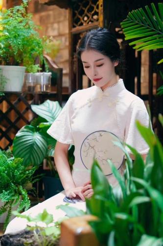 a woman standing next to a table with plants at 云海酒店 in Zhangjiajie