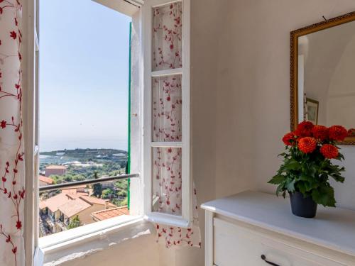 ein Fenster in einem Zimmer mit einer Blumenvase in der Unterkunft Locazione Turistica Marina by Interhome in Terzorio