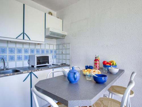 - une cuisine avec une table et des bols bleus dans l'établissement Studio Les Lavandes-17 by Interhome, à Saint-Cyr-sur-Mer
