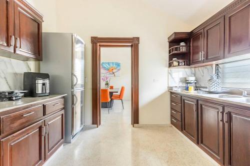 a kitchen with wooden cabinets and a refrigerator at Paramount Views in San Felipe de Puerto Plata