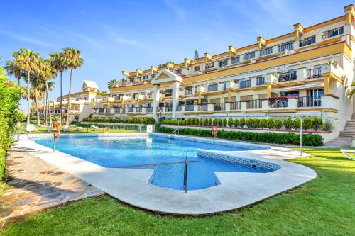 un hotel con piscina frente a un edificio en Super2beachfront, en Marbella