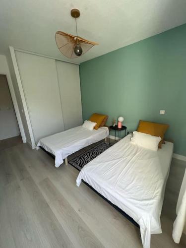 a bedroom with two beds and a ceiling fan at Appartement avec piscine in Calvi