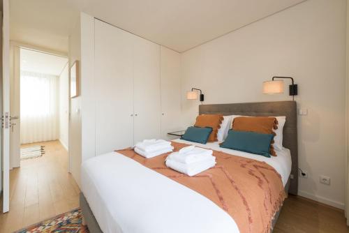 a bedroom with a large bed with two pillows at AgapeStay Family House in Porto