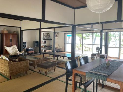 奈多みどり荘 Nada Beach House في Kitsuki: غرفة معيشة مع طاولة وكراسي