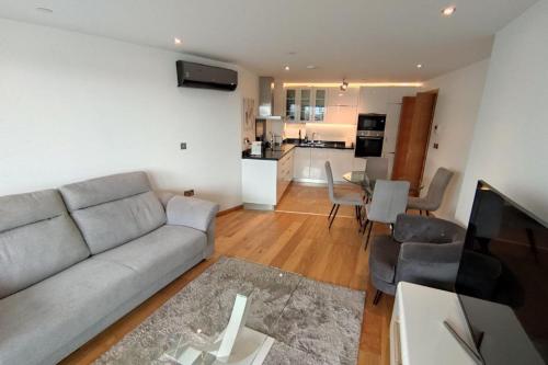 a living room with a couch and a kitchen at Seaside Serenity Oasis - High floor - Stunning Views in Gibraltar