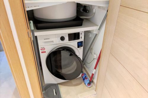 a washer and dryer in a small room at Seaside Serenity Oasis - High floor - Stunning Views in Gibraltar